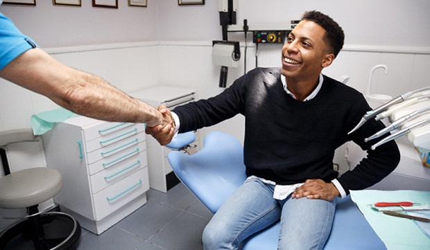 A young man shaking the hand of a dentist