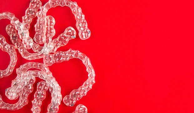 Invisalign clear braces on red background